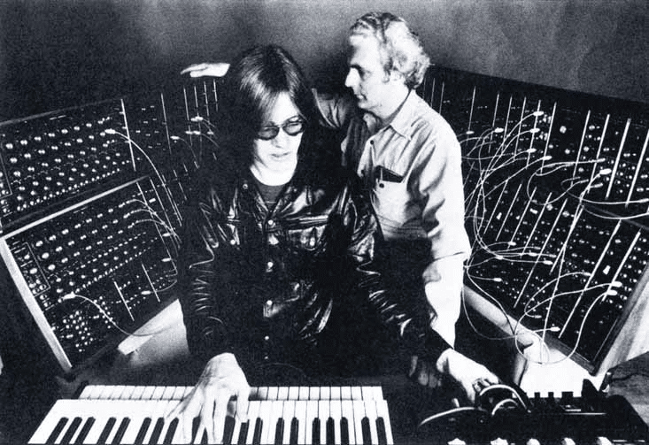 Roger Powell, Keyboarder bei Todd Rundgrens Utopia, spielt seine Spezialanfertigung des<br /><br /> Moog-Modular-Systems, während Bob Moog eines seiner eigenen Werke begutachtet.