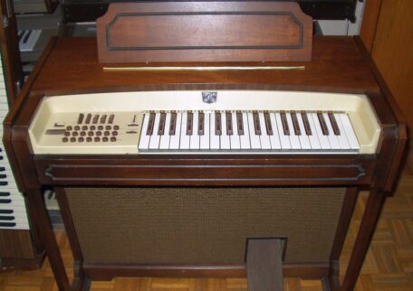 Vintage Optigan Heimorgel mit Holzgehäuse, Tastatur, Begleittasten und Lautsprecherfront.