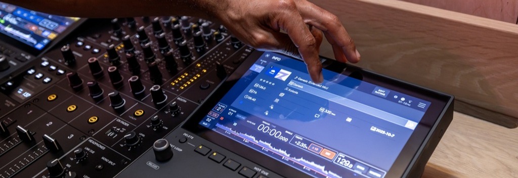 AlphaTheta CDJ-1500X DJ-Multiplayer mit Touchscreen im Einsatz, während ein DJ einen Track auf dem Display auswählt.